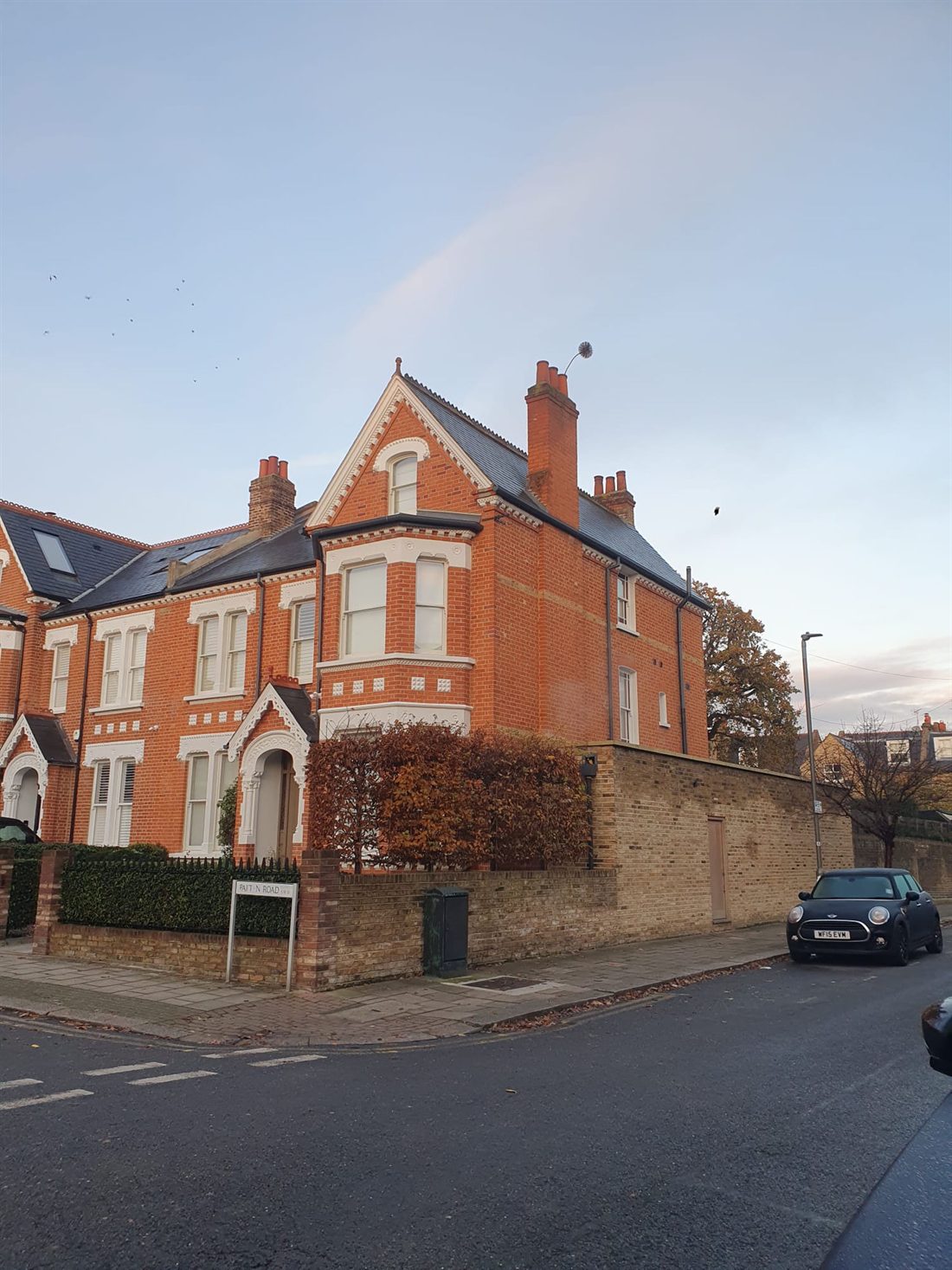 A chimney sweep's brush pushed right through the top of a chimney pot on a Victorian house