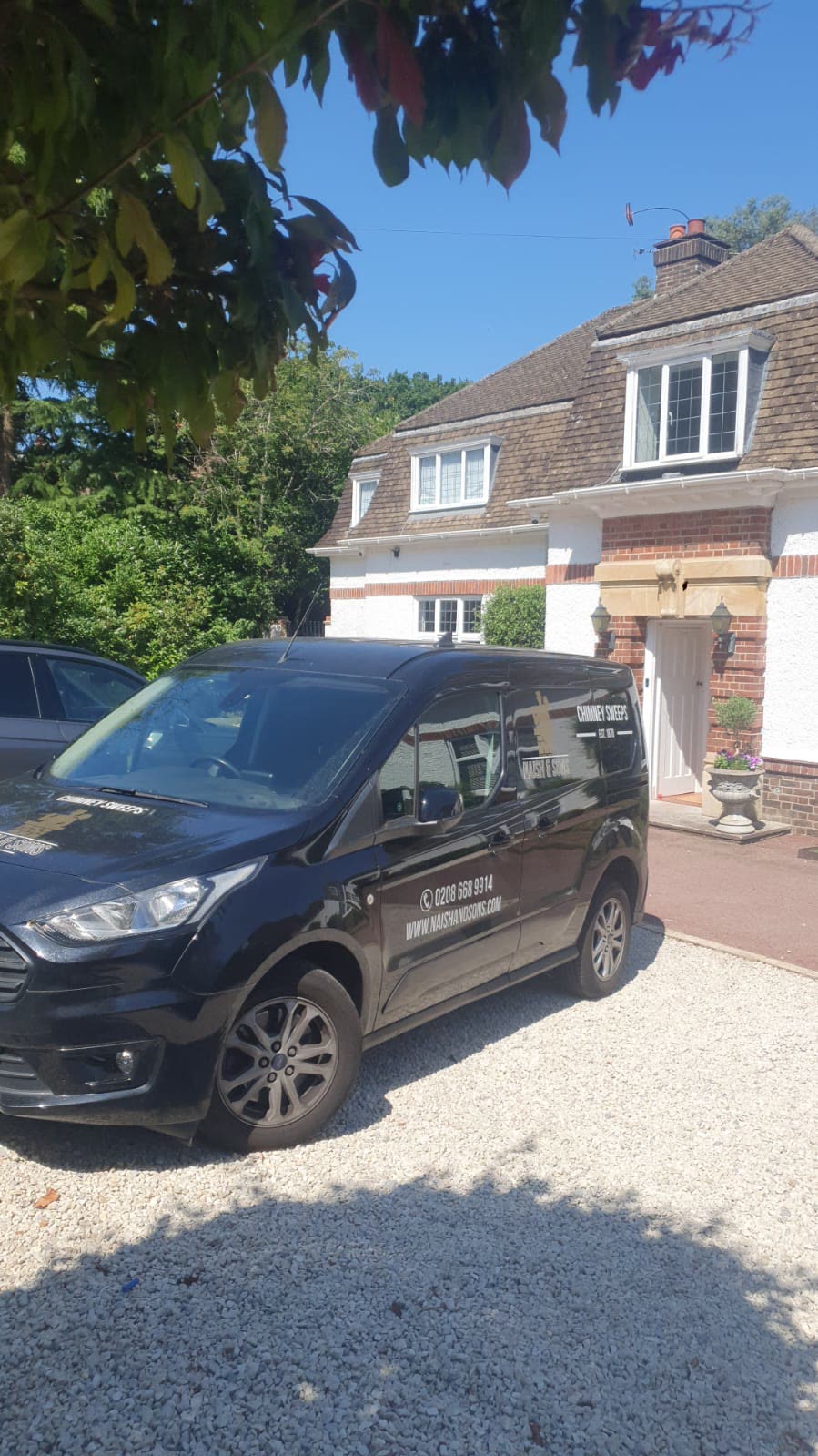The Naish & Sons van on a gravel drive outside a period house